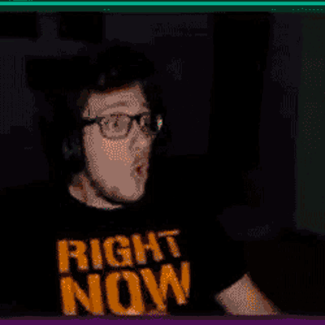 a man wearing glasses and a black shirt that says right now on it