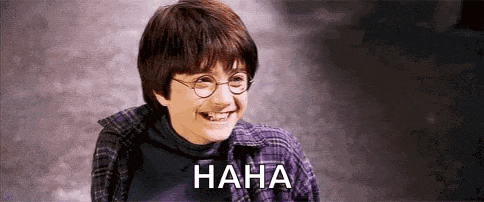 harry potter is smiling and laughing with the words `` haha '' written on the bottom .