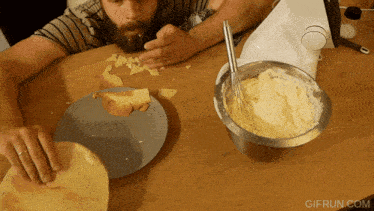 a gif from gifrun.com shows a man eating a slice of cheese