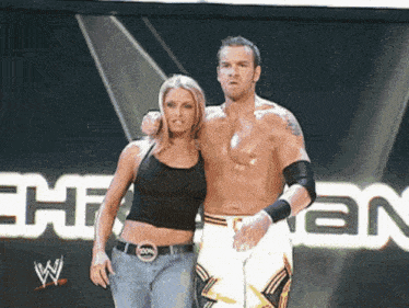 a man and a woman are standing in front of a sign that says ehman