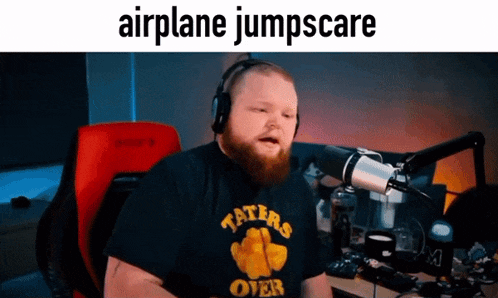 a man with a beard wearing headphones and a shirt that says taters over
