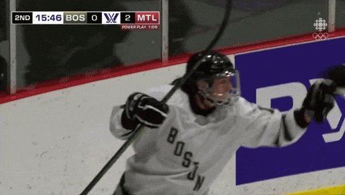 a hockey player in a boston jersey holds a stick