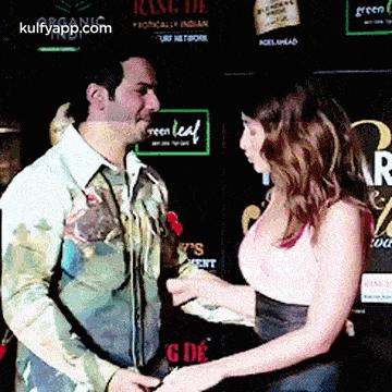 a man and a woman are standing next to each other and the woman is holding the man 's hand .