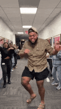 a group of people are dancing in a hallway with a exit sign in the background