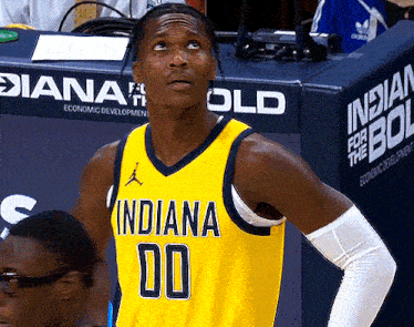 a basketball player wearing a yellow indiana jersey looks up