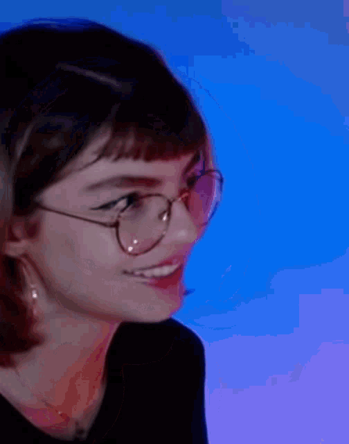 a close up of a woman wearing glasses and a black shirt .