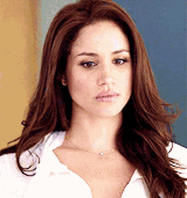 a woman with long brown hair is wearing a white shirt