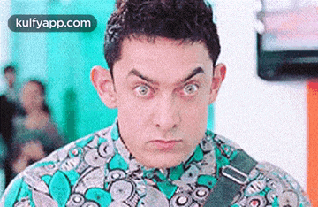 a close up of a man making a funny face while wearing a green shirt and tie .