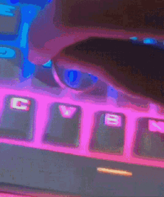 a close up of a keyboard with pink and blue keys and the shift key visible