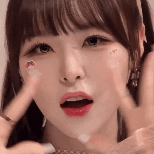 a close up of a girl 's face with a hello kitty sticker on her cheek