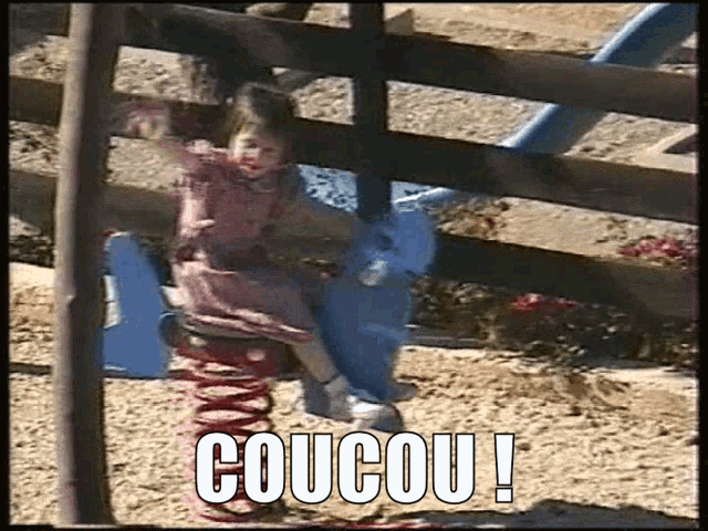 a little girl is sitting on a spring rider at a playground with the words coucou written on the bottom .