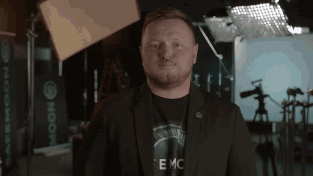 a man wearing a shirt that says emc stands in front of a camera
