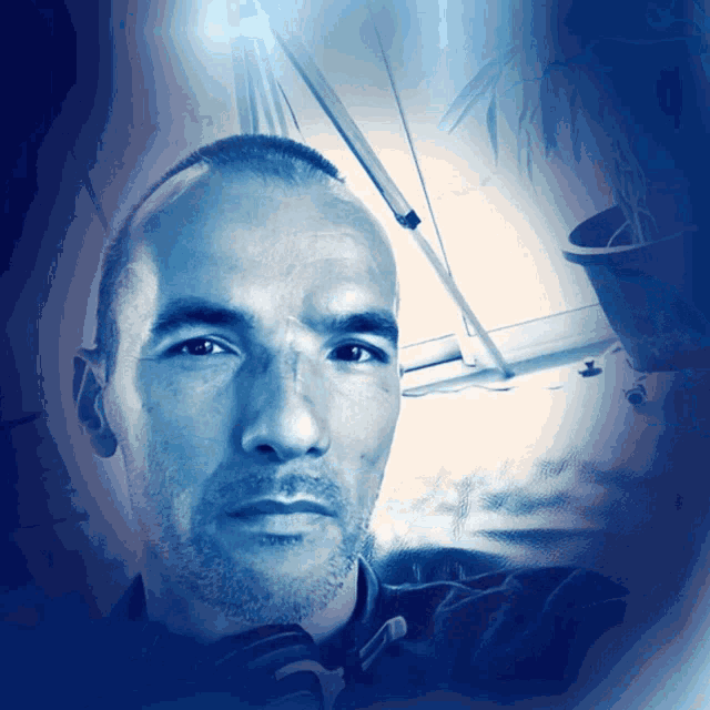 a man with a shaved head looks at the camera