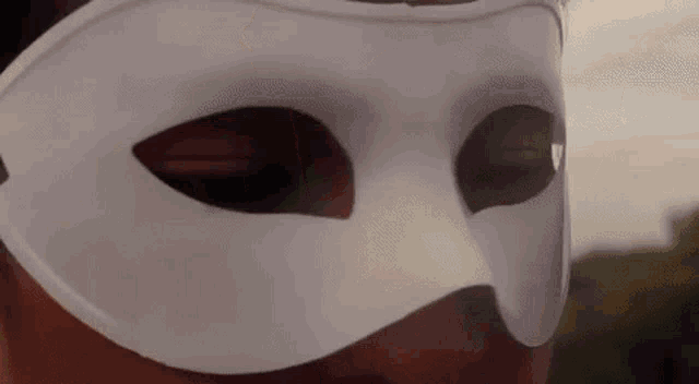 a man is wearing a white mask on his face .