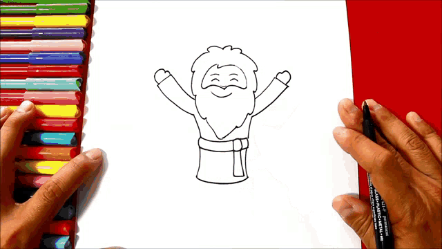 a person is drawing a cartoon of santa claus with markers