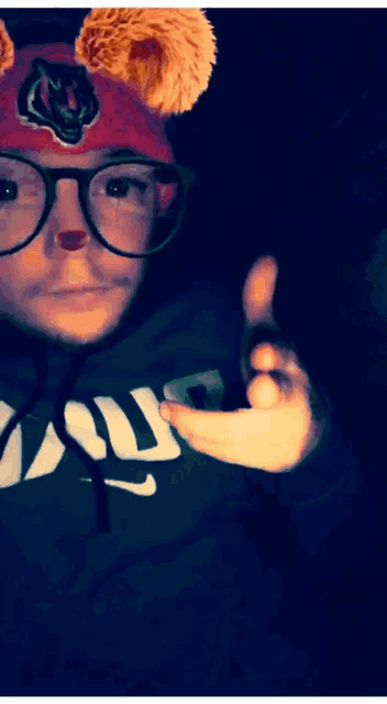 a person wearing glasses and a hat with a tiger on it is wearing a nike hoodie