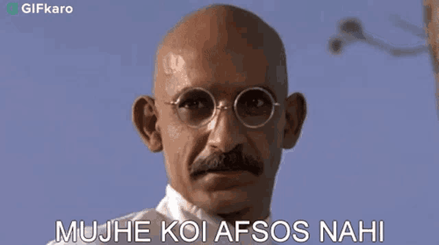a bald man with glasses and a mustache is making a funny face and saying mujhe koi afsos nahi .