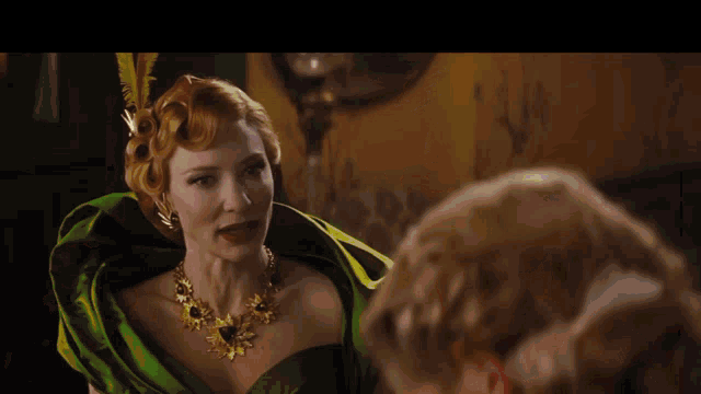 a woman in a green dress with a gold necklace