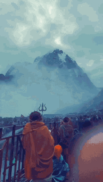 a man sitting on a balcony looking at a mountain