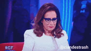 a woman wearing glasses sits in front of a blue background with the hashtag #gf