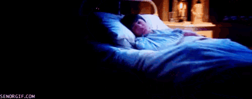 a boy is sleeping in a bed with a blue blanket .
