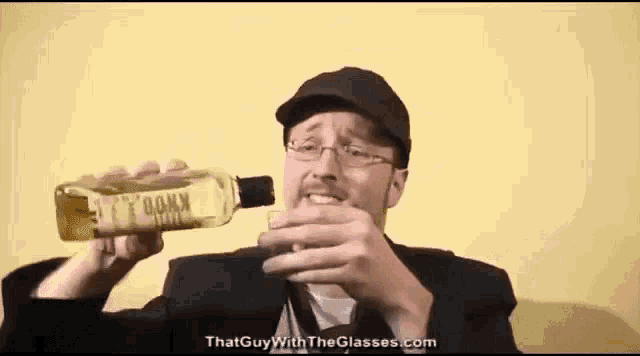 a man with glasses is drinking from a bottle that says knox