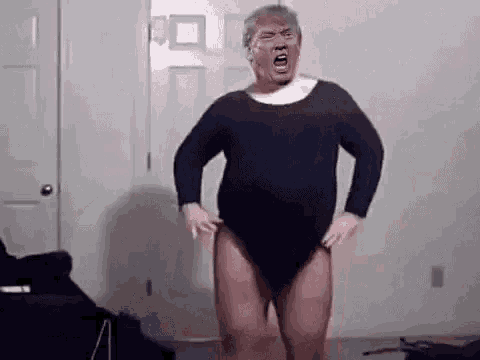 a man in a black leotard is standing in a room with his mouth open .
