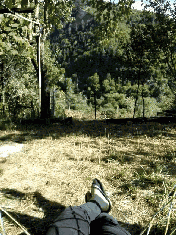 a person laying in a hammock with their feet up in the air