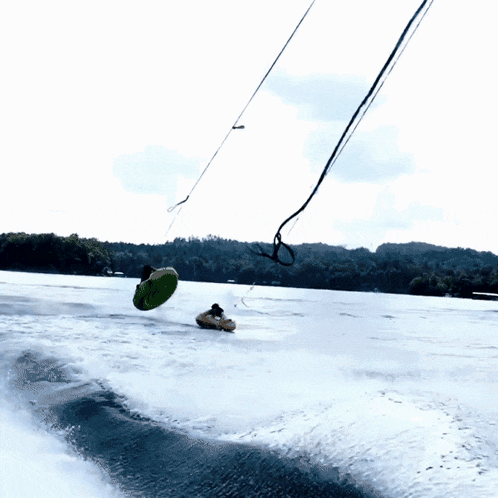 a person in a green tube is being pulled by a boat