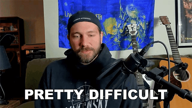 a man sitting in front of a microphone with the words " pretty difficult " on the bottom