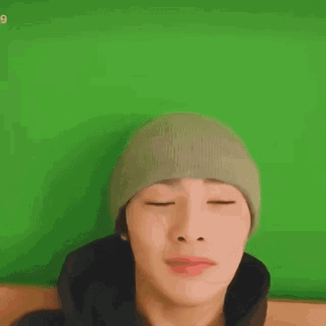 a close up of a person wearing a beanie and a black hoodie .