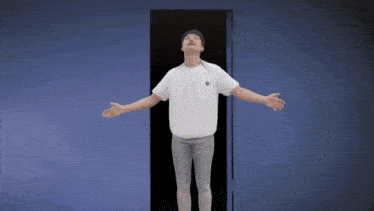 a man with his arms outstretched is standing in front of a door