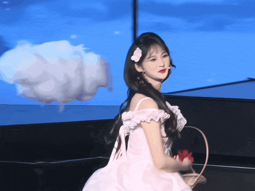 a girl in a white dress with a flower in her hair is holding a basket