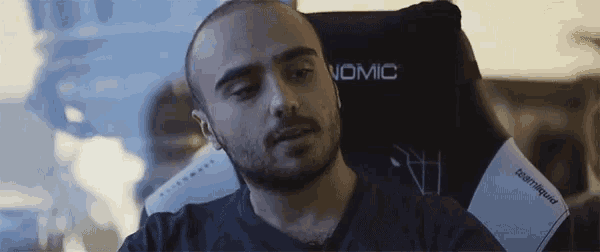 a man sits in a chair with the word vomic on the back