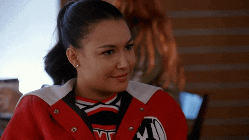 a cheerleader wearing a red jacket with the letter m on the front