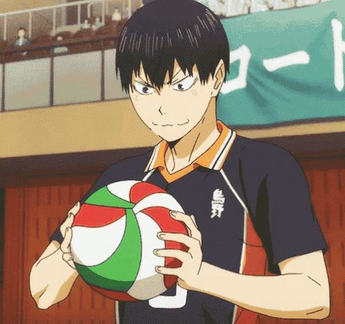 a man holding a volleyball in front of a sign that says 1