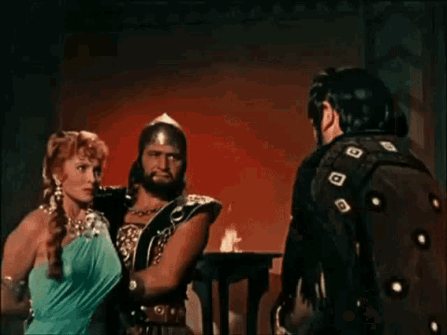 a man and a woman are standing next to each other in a movie .