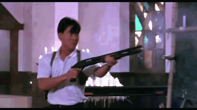 a man is holding a shotgun in front of a stained glass window in a room .