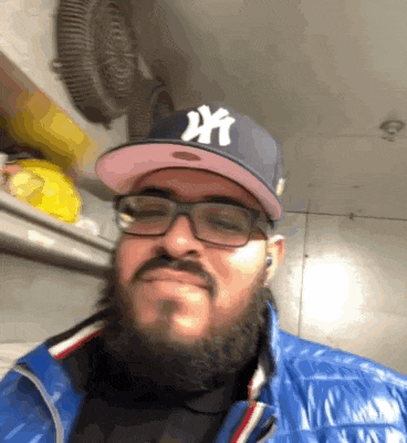 a man with a beard wearing a new york yankees hat