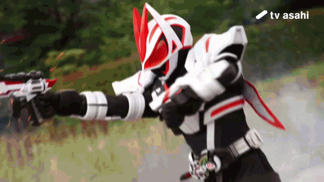 a man in a mask is holding a gun with the tv asahi logo in the background
