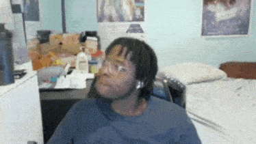 a man wearing glasses is sitting in front of a star wars poster on the wall