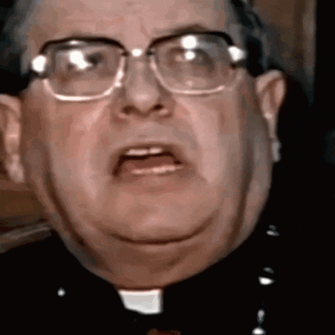 a close up of a man wearing glasses and a priest 's collar .