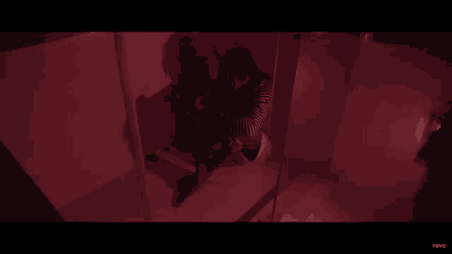 a video of a person sitting in front of a mirror with the word vevo on the bottom