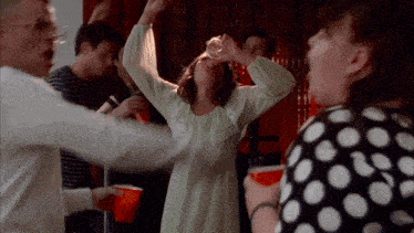 a woman in a green nightgown drinks from a red cup