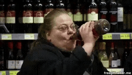 a woman is drinking from a bottle in a store .