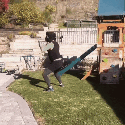 a person is doing squats in front of a playset