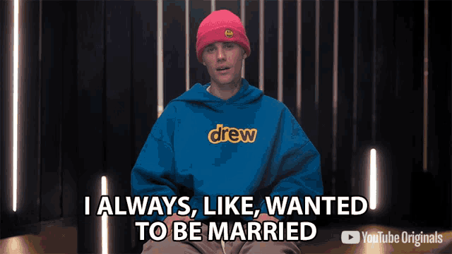 justin bieber is wearing a blue drew hoodie and a pink beanie