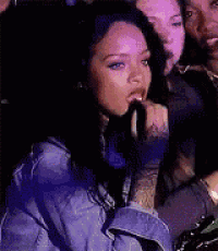 a woman in a blue denim jacket is sitting in a crowd of people .