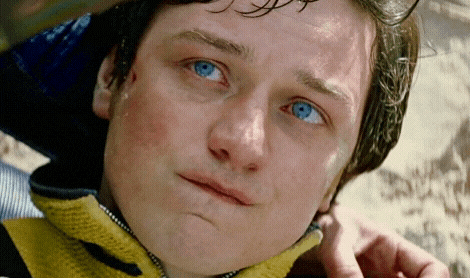 a close up of a person 's face with blue eyes and a yellow jacket