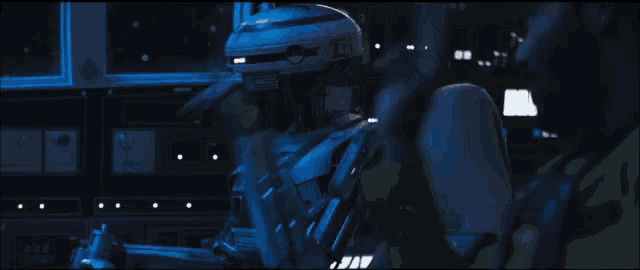 a man talking on a cell phone next to a robot in a dark room